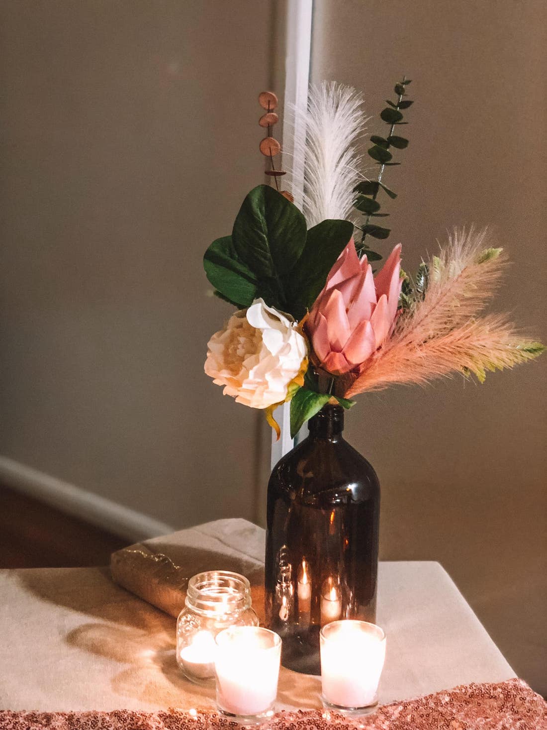 Simple party table styling with candles and floral arrangement