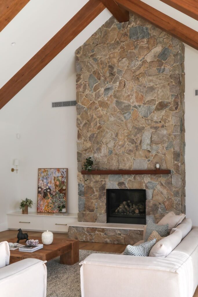 Modern farmhouse living room with tall stone fireplace