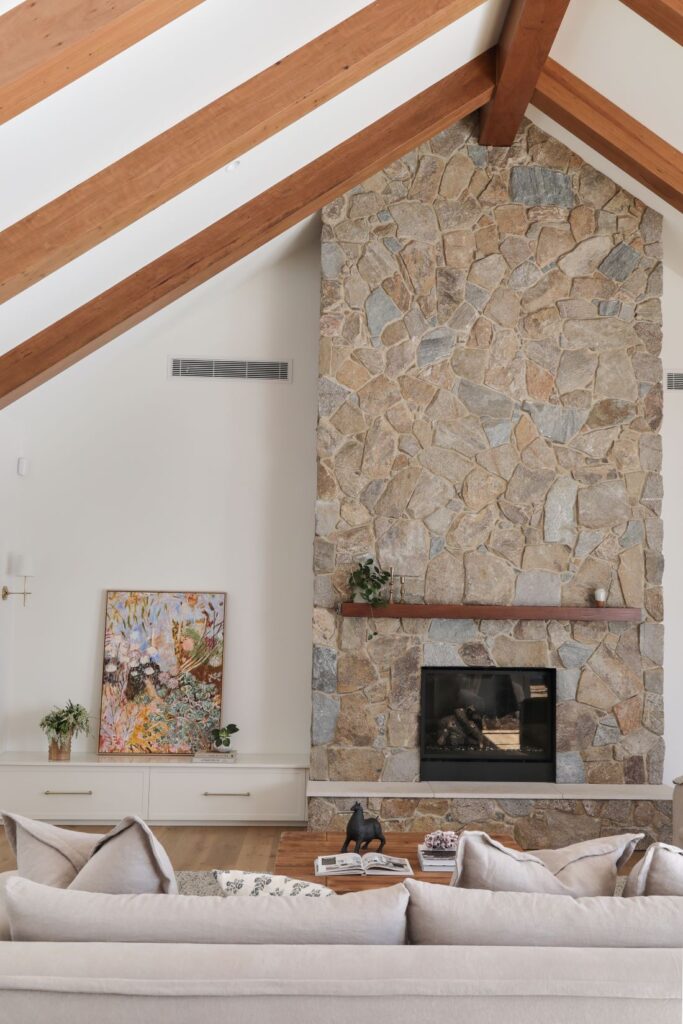 Vaulted living room with timber beams and stone fireplace