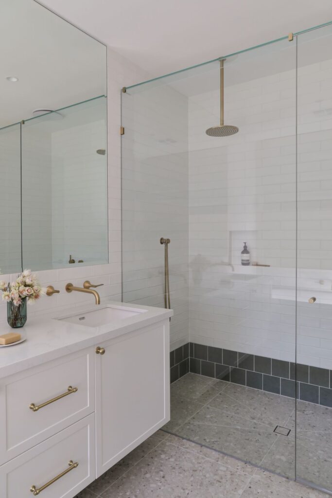 Bathroom with glass shower brass fixtures and white subway tiles