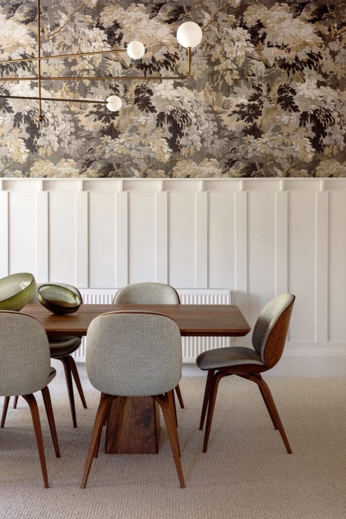 Wall with half height paneling below and wallpaper to the ceiling above