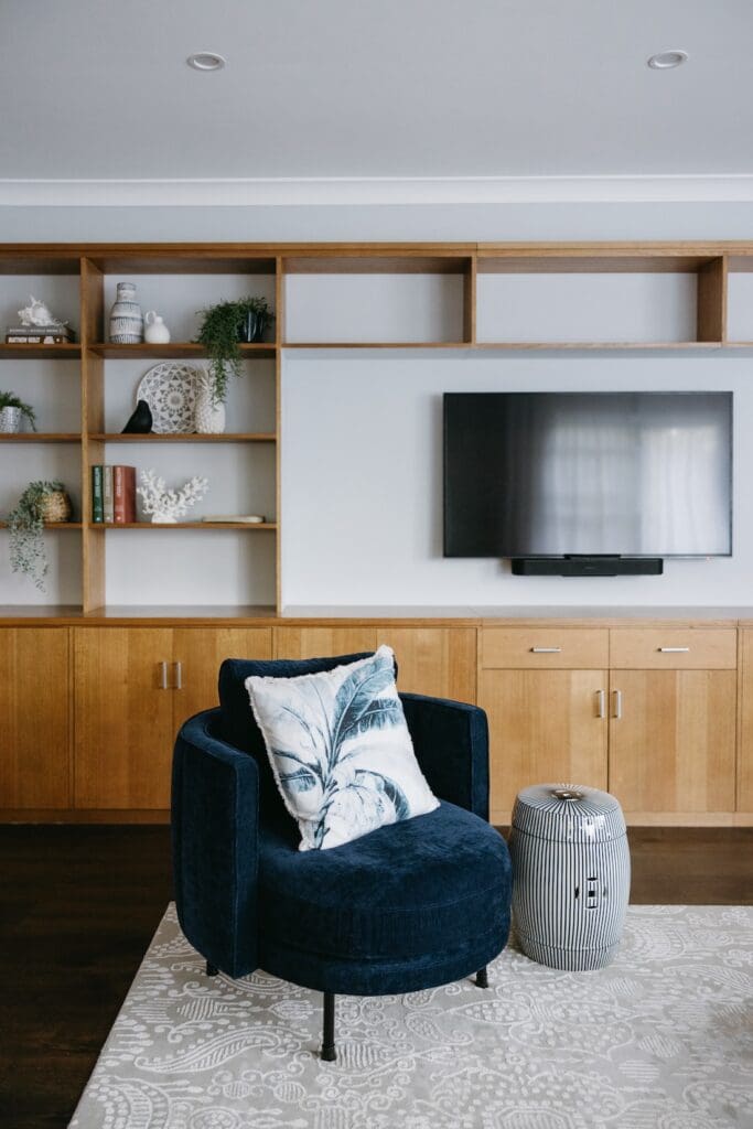 Blue velvet armchair in living room with custom joinery