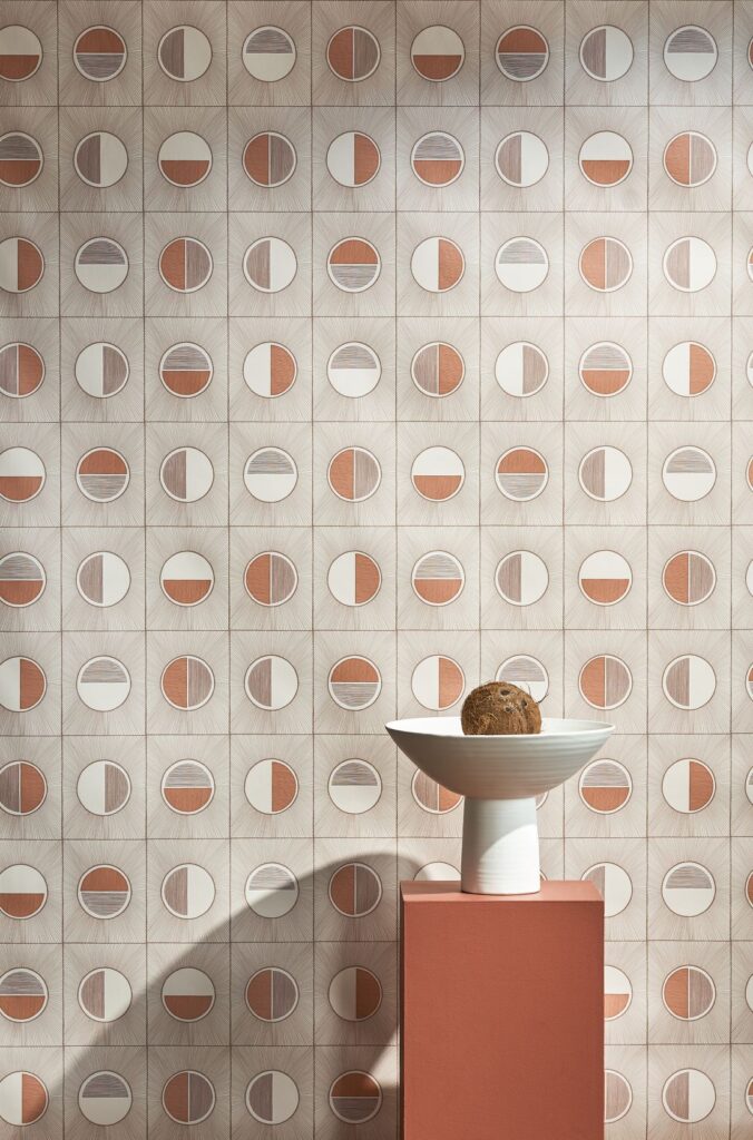 Solar Rays Wallpaper by Patricia Braune featuring a geometric pattern with circular designs in earthy tones, complemented by a ceramic bowl and pedestal.