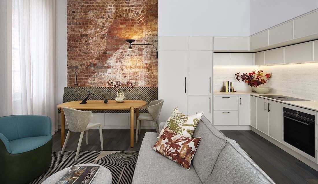 Original exposed brick wall in dining nook of Tribeca Brewery apartment by The Stylesmiths