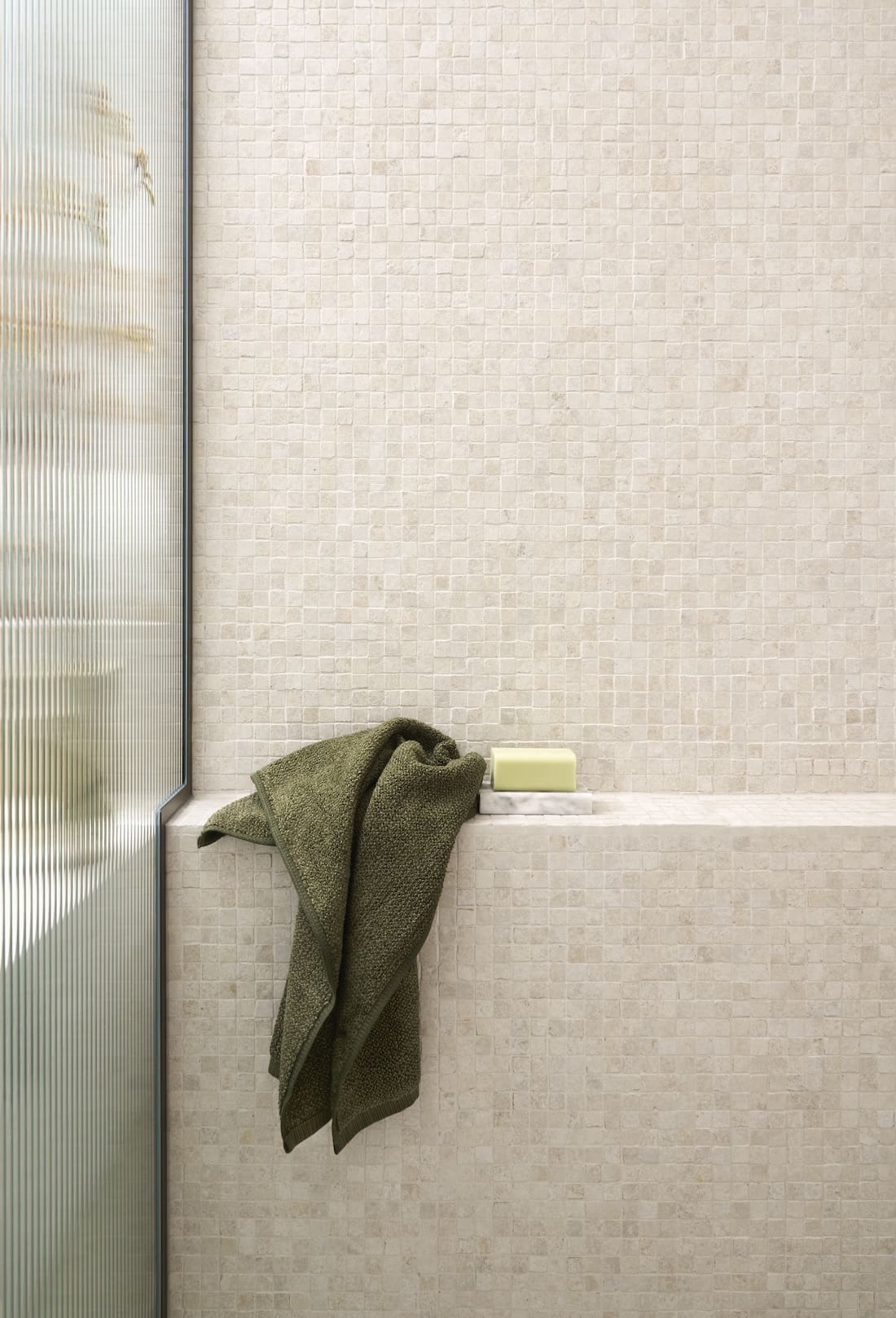 Tiled shower wall and seat in shower in Tribeca Brewery apartment by The Stylesmiths
