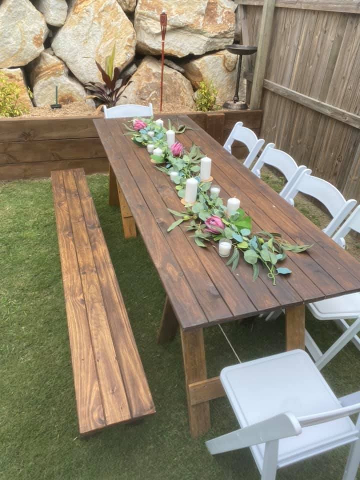 Outdoor party table with greenery and candle centerpiece